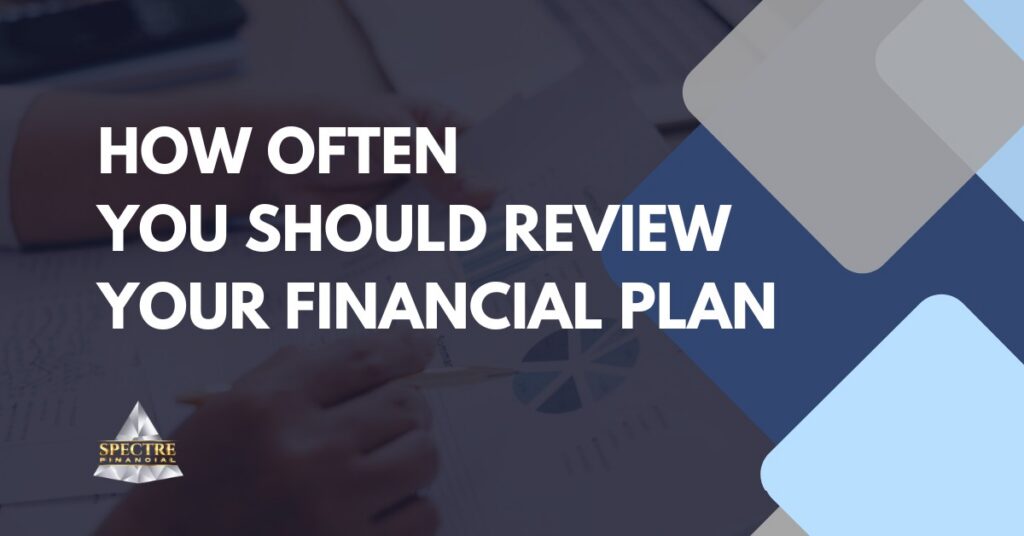 Text on a graphic reads: "How often review financial plan?" The background shows a blurred hand holding a pen over documents with charts. The logo "Spectre Financial" appears in the lower left corner.